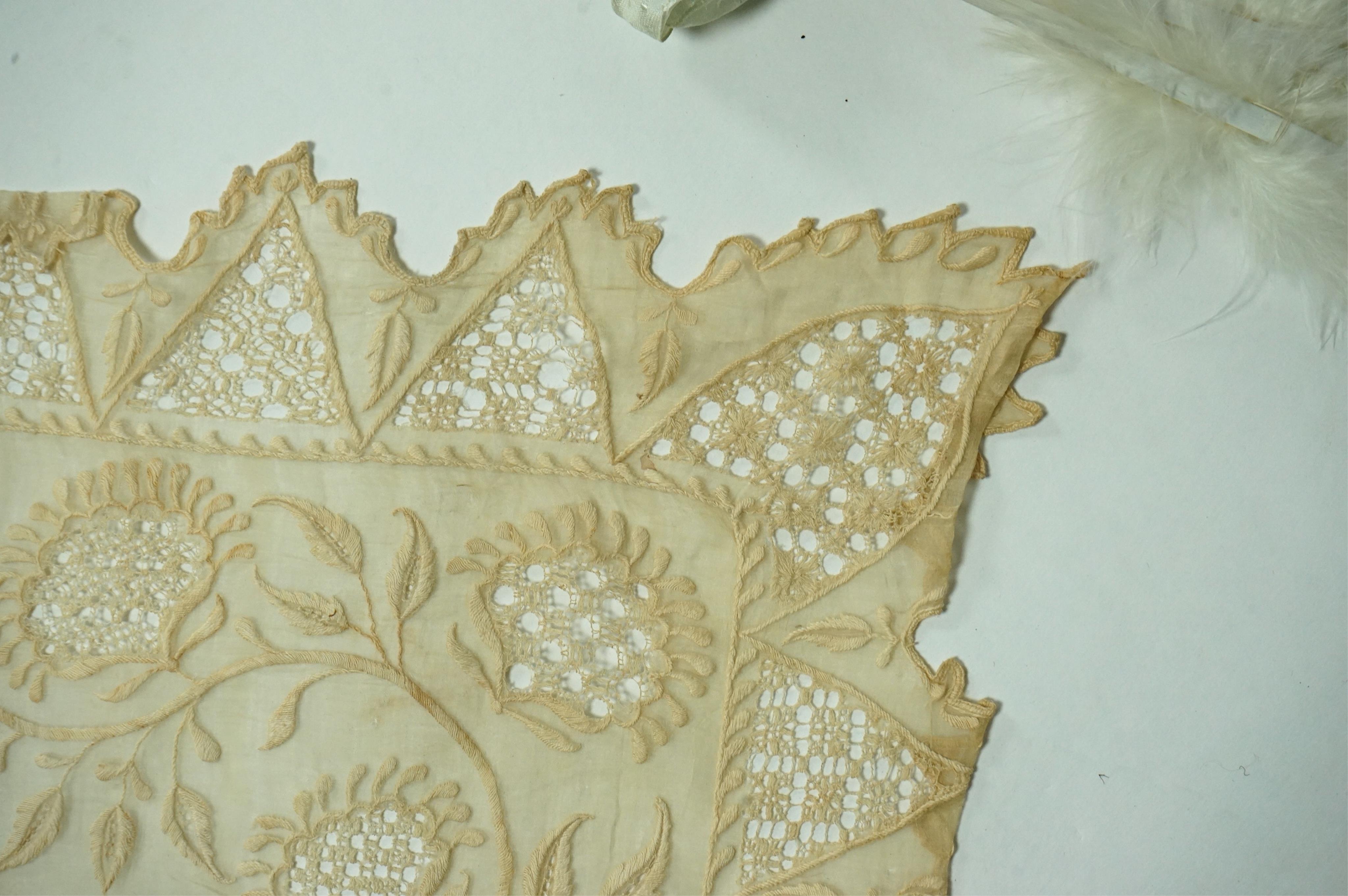 A 1920’s wax wedding headdress, a white feather fan, a bone brise and an earlier long lawn embroidered and lace worked stole., Stole 194cm long. Condition - headdress and fan good, stole has moth holes in places but can